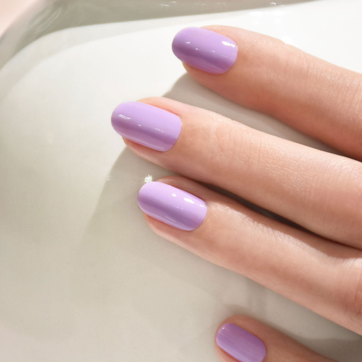 A close-up of a hand with neatly manicured nails painted in a glossy green shade using Manucurist&