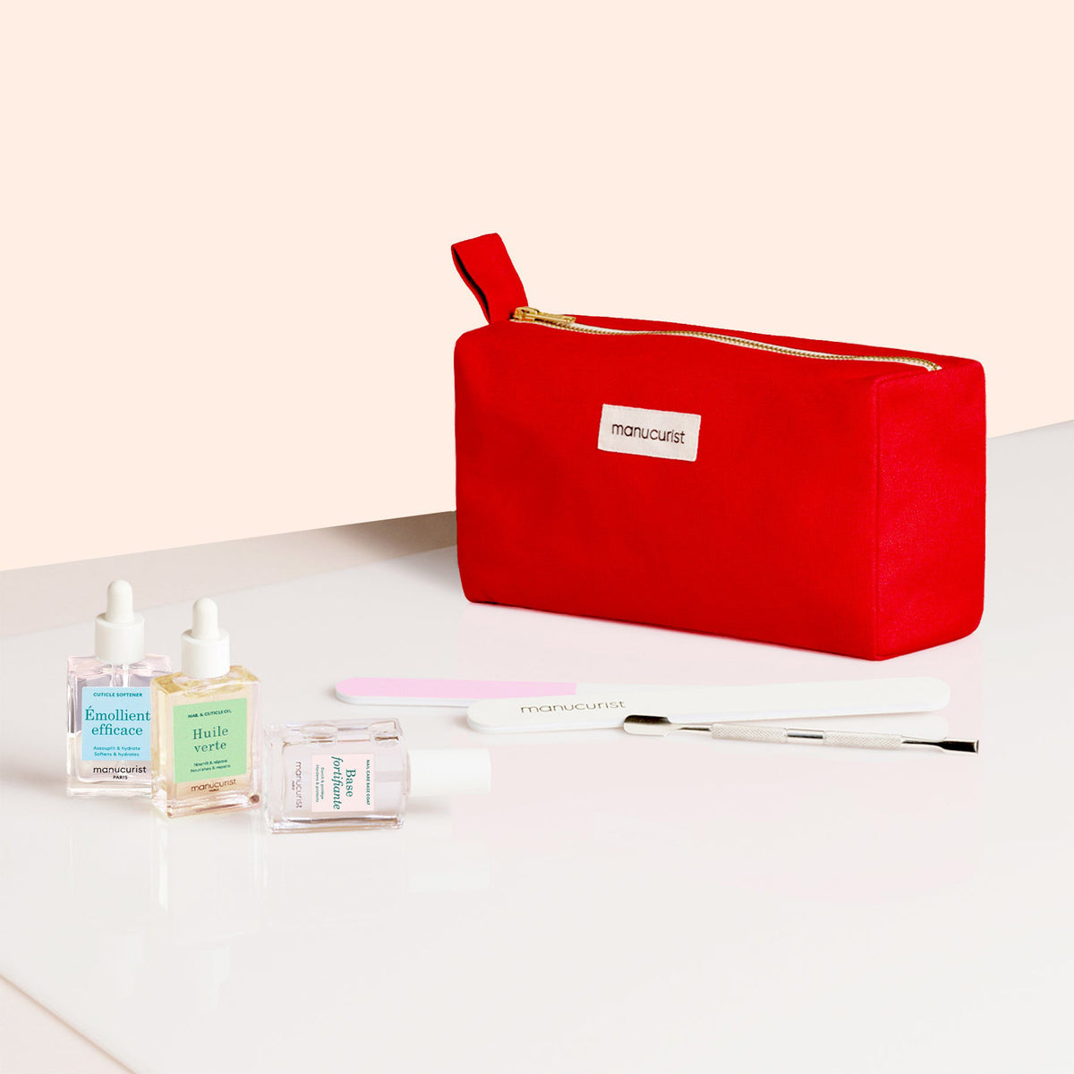 The Manucurist Complete Nail Care Kit includes a red zippered pouch on a white surface with three nail care bottles, a cuticle softener, nail file, and metal cuticle tool for easy nail prep.