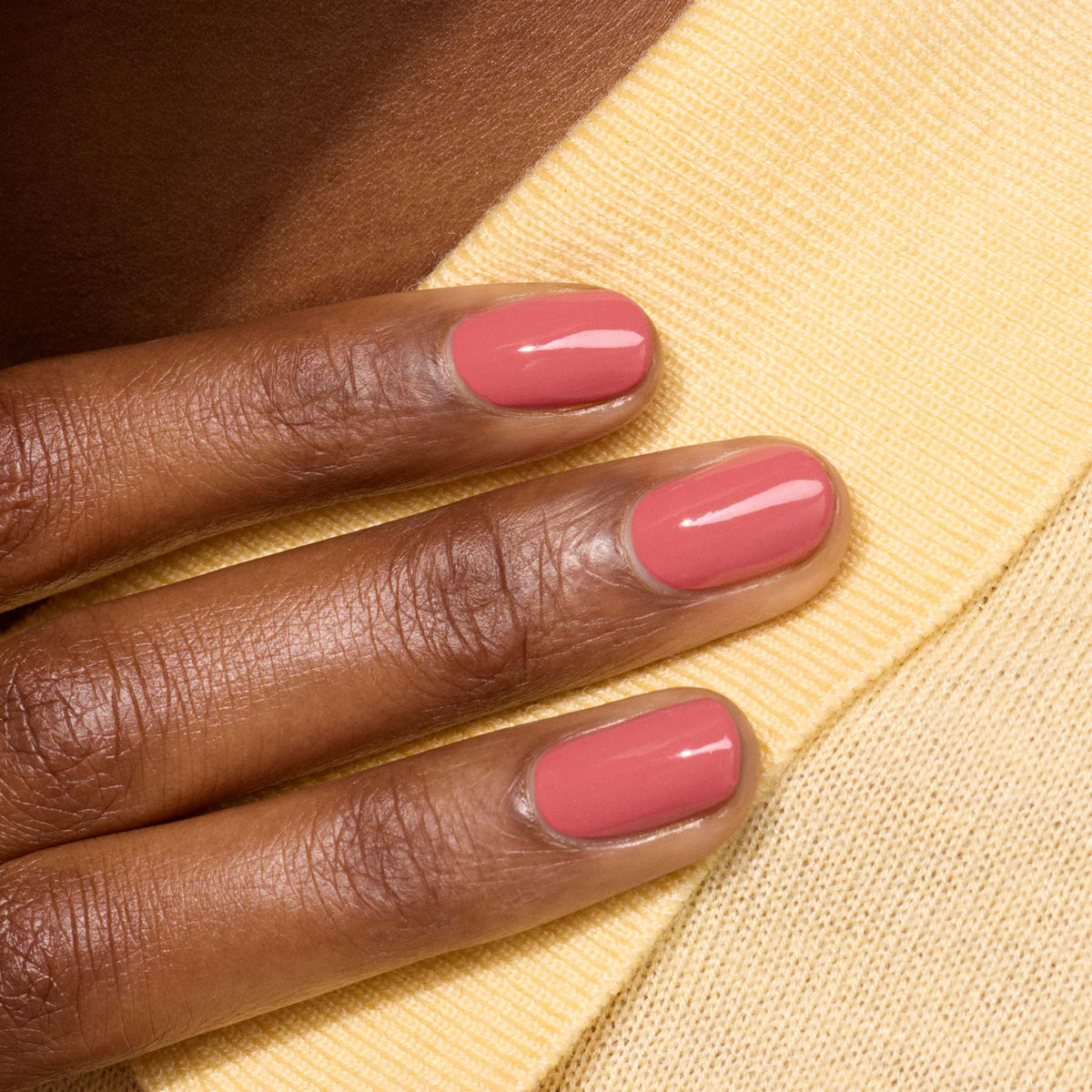A close-up of a hand with short, neatly manicured nails painted in Manucurist&