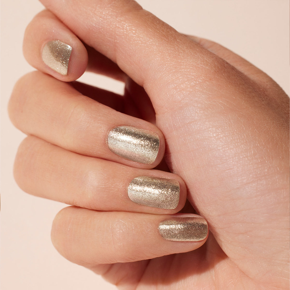 A close-up of a light-skinned hand with neatly manicured nails painted in Manucurist&
