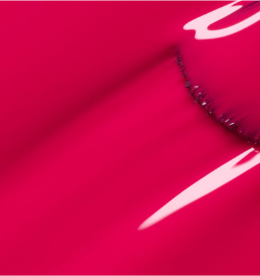 A close-up of a shiny, bright pink surface with smooth curves and reflective highlights, creating an abstract and glossy appearance.