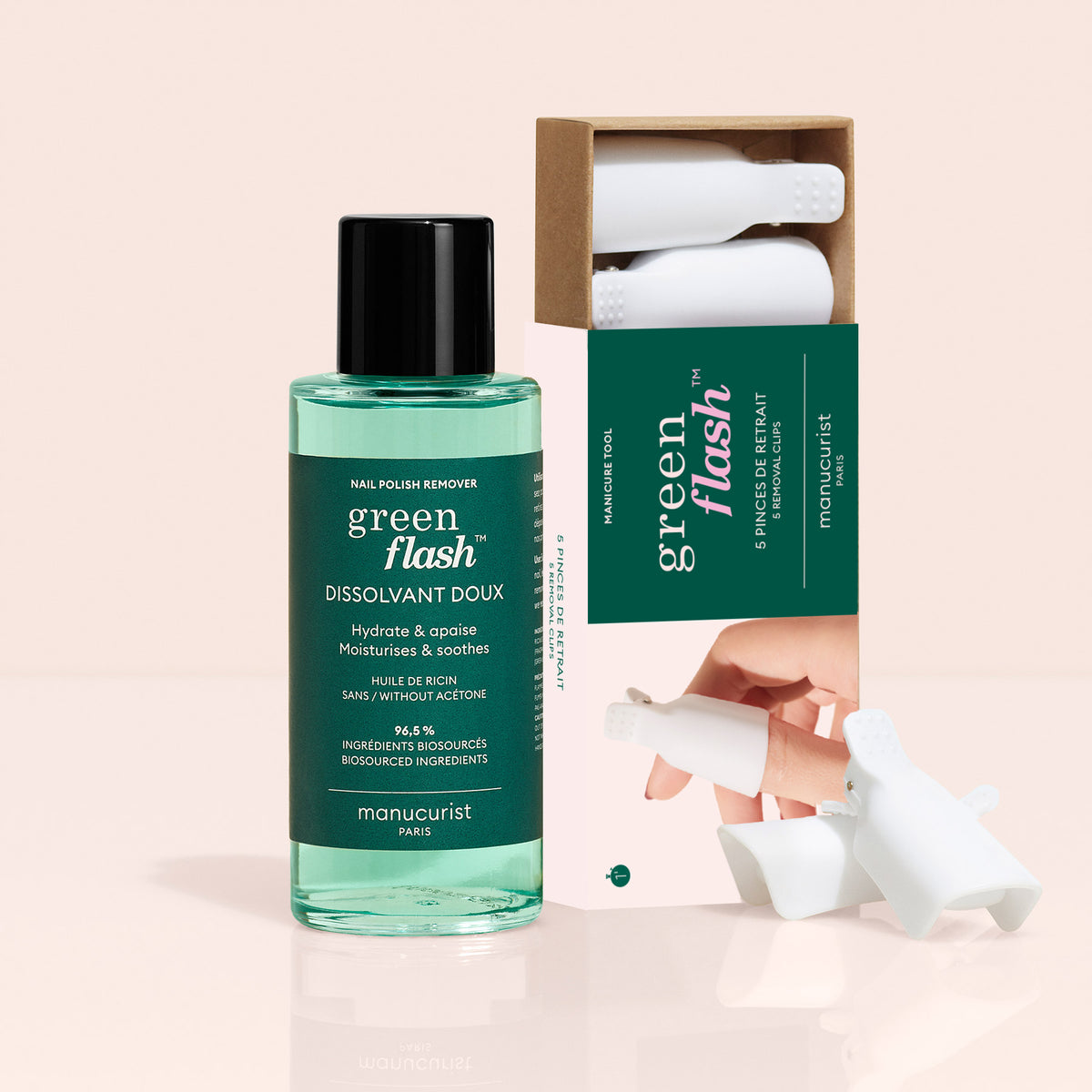 The Manucurist-us Green Flash™ Remover Clips Duo, featuring a plant-based remover bottle and a box of five white finger clips for gentle polish removal, is displayed against a soft beige background.