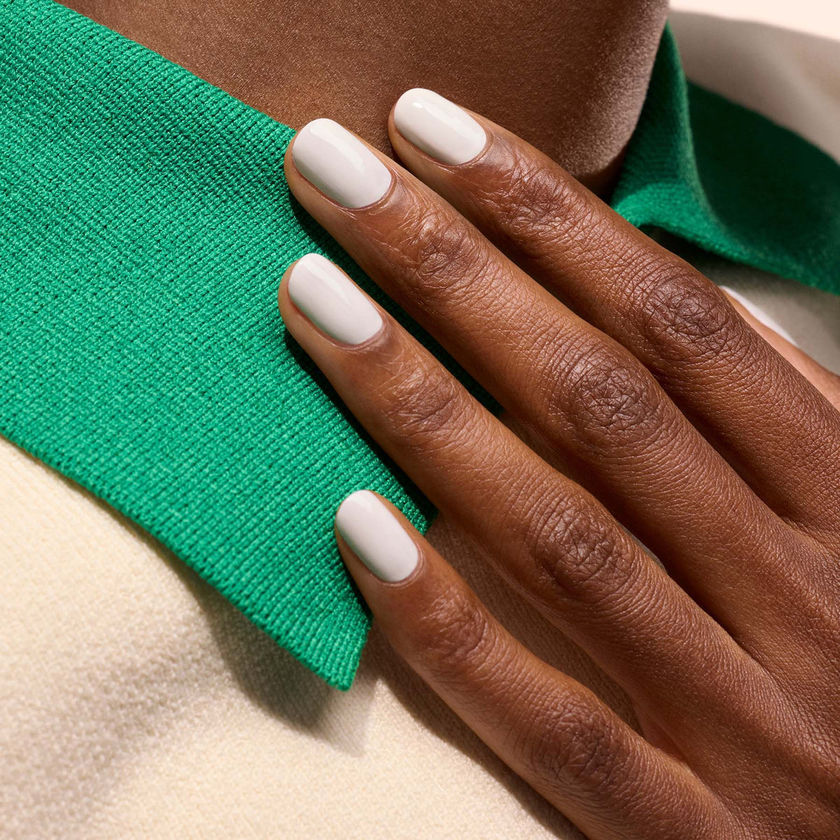 A hand with neatly manicured, short nails coated in Manucurist&