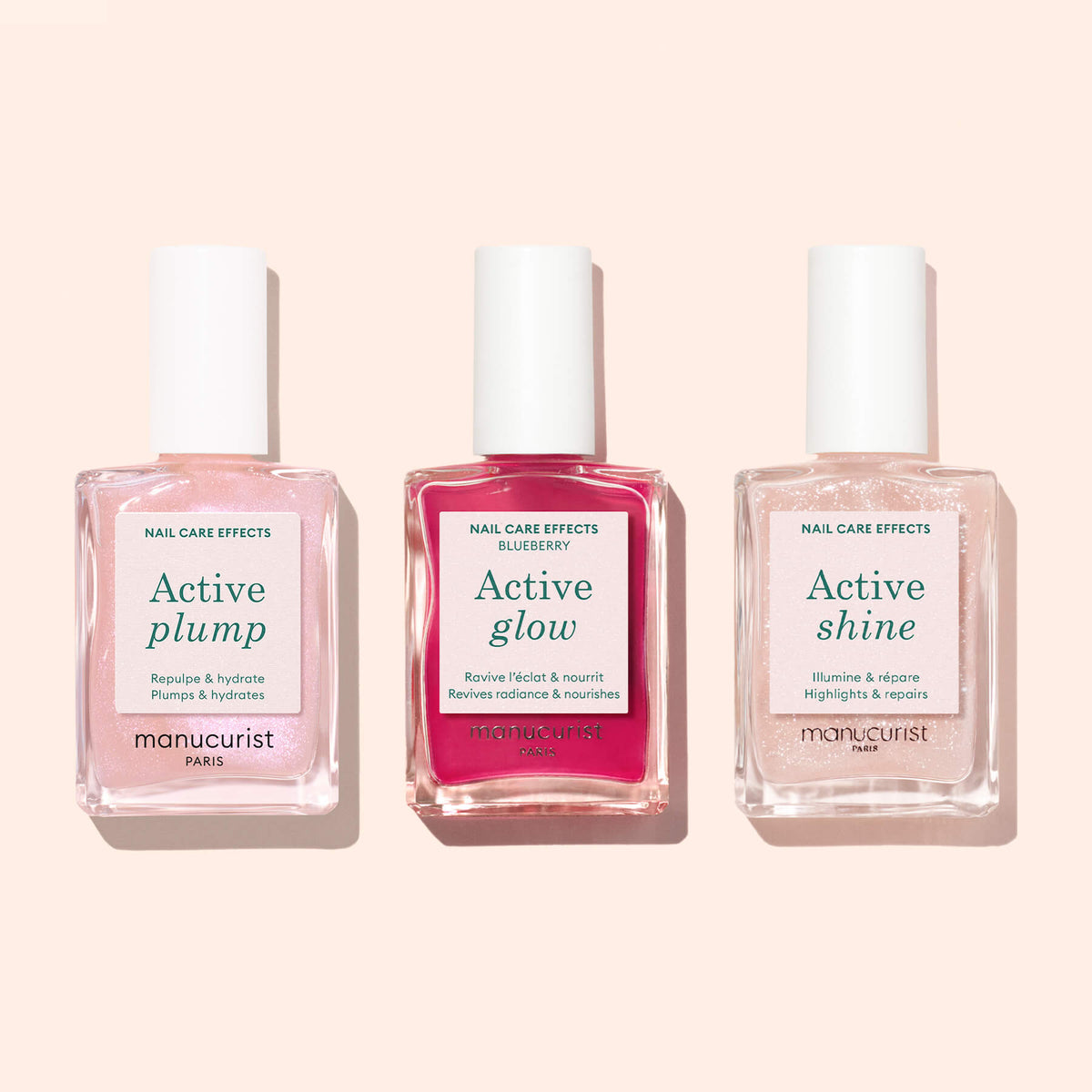 Trois flacons de soins pour les ongles d’origine végétale Manucurist, dont Active™ Plump Pink Glazed, Active Glow et Active Shine, sont alignés côte à côte sur un fond rose pâle — le trio idéal pour des ongles hydratés.