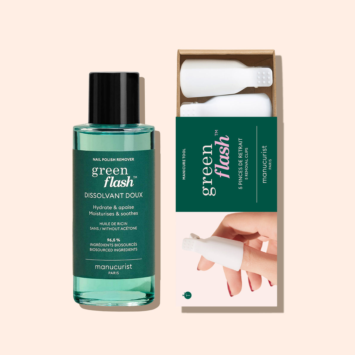 A bottle of Manucurist-us Green Flash™ Remover Clips Duo stands beside an open box with five reusable fingertip clips, each featuring a white textured cap. The background is a soft beige color.