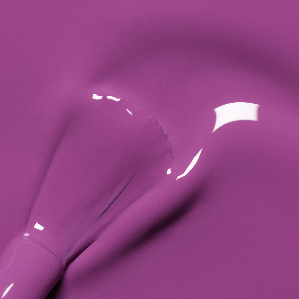 A close-up of a brush applying Violette nail polish from Manucurist, creating smooth, glossy streaks and vibrant reflections on the surface.
