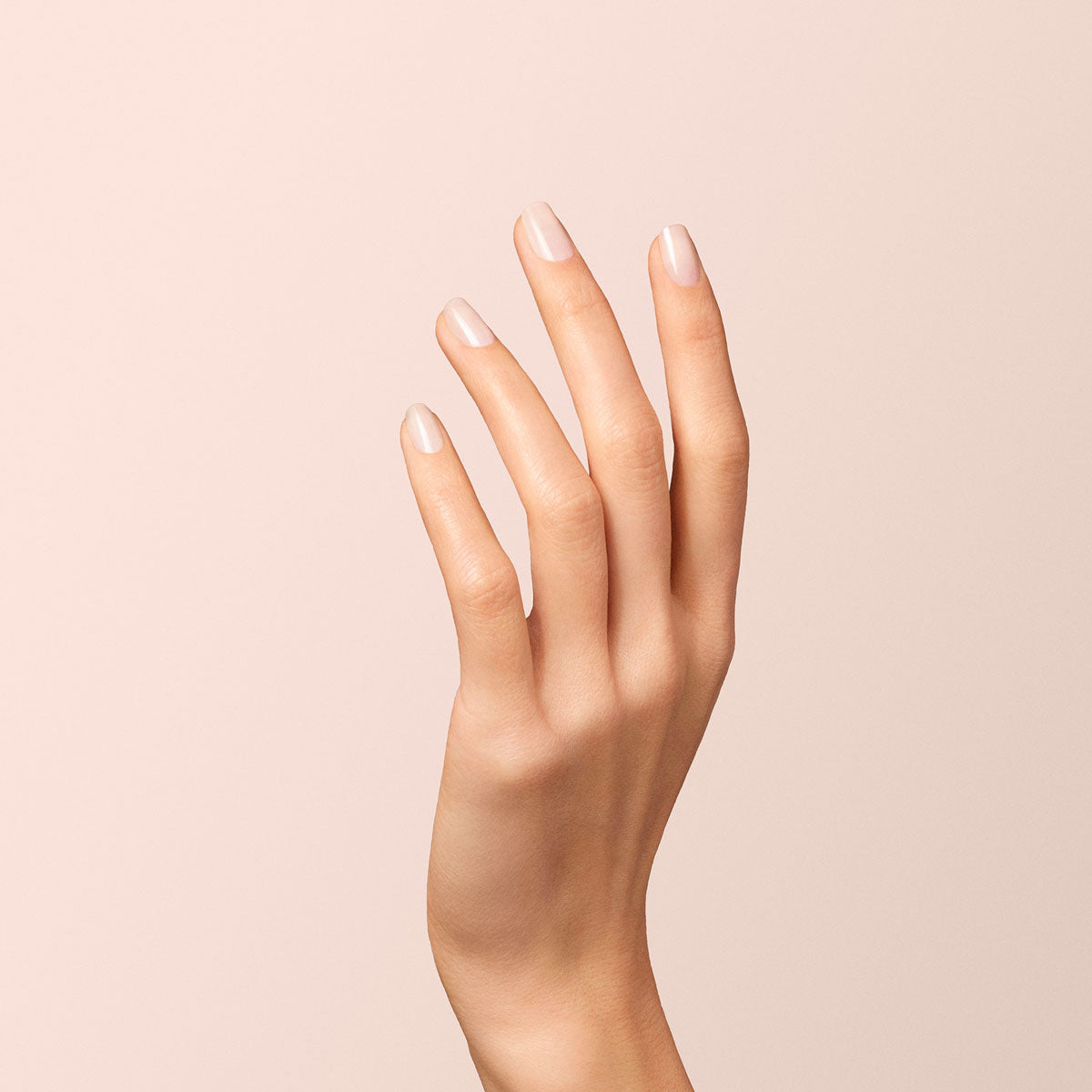 A close-up of a hand with slender fingers and neatly manicured nails painted in Manucurist&