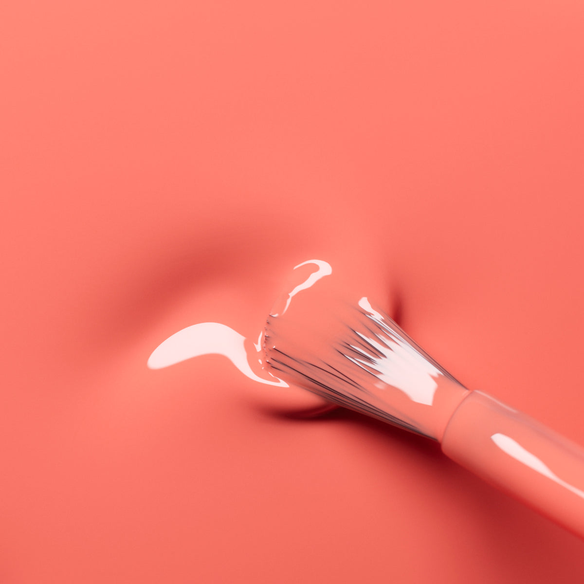A paintbrush leaves a mark on a smooth, Bird of Paradise coral surface from Manucurist, with glossy white paint on its bristles and a small smear of coral orange gel polish on the nail.