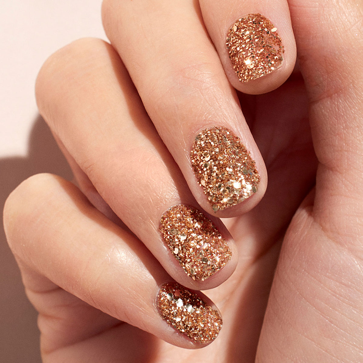Gros plan sur des ongles maquillés avec les paillettes biodégradables Rose Gold de Manucurist, pour une manucure scintillante et festive, éco-responsable et parfaite pour un nail art chic.