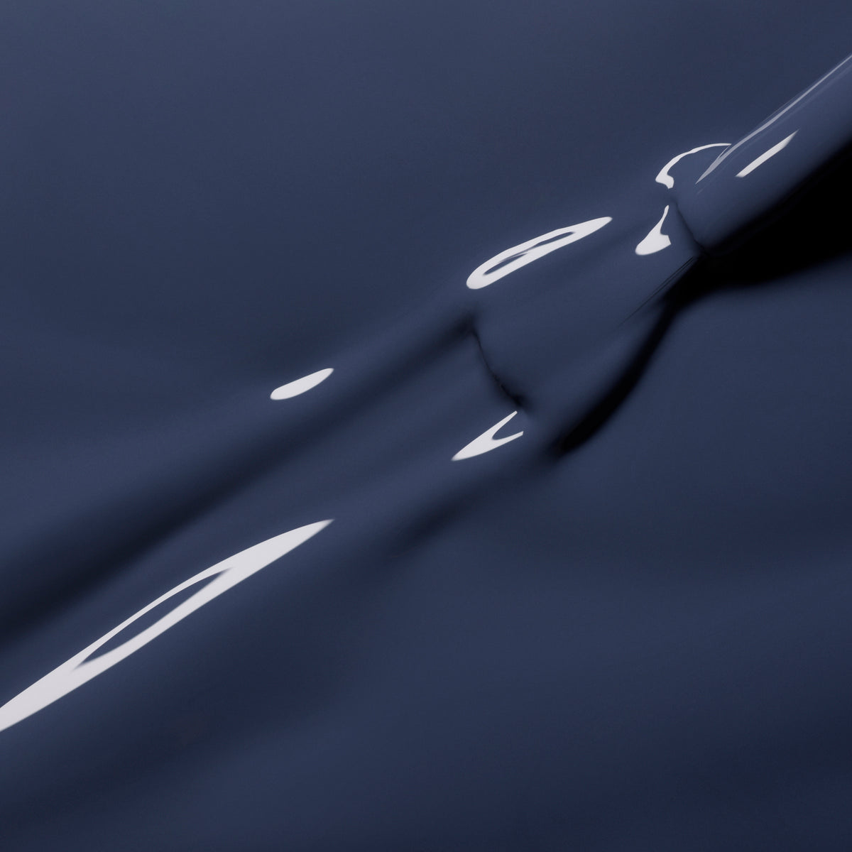 Close-up of a smooth, bluish grey liquid surface with gentle ripples and reflections, evoking abstract shapes and fluid motion in elegant shades reminiscent of Poppy Seed by Manucurist.