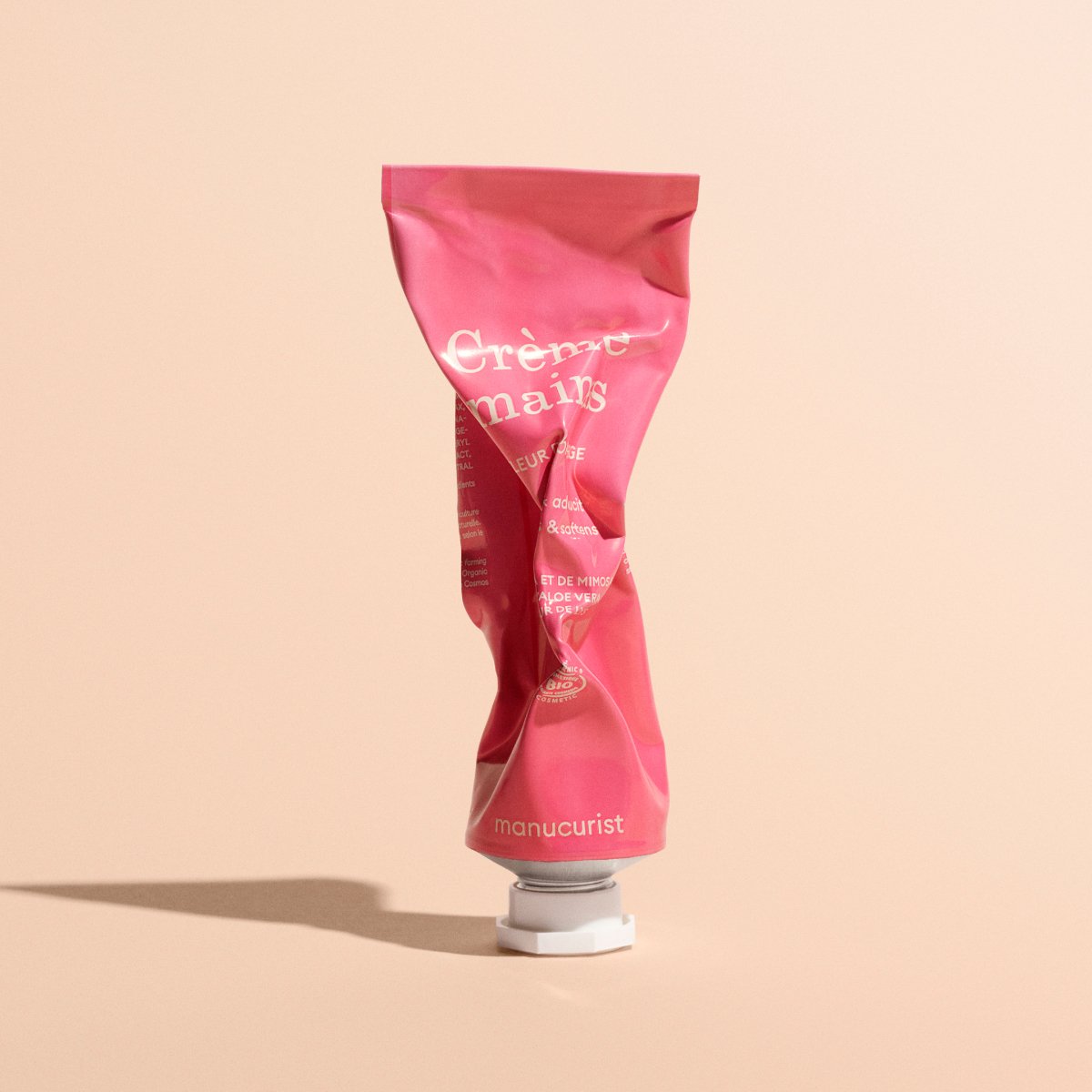 Un tube rose froissé de Crème Mains Fleur d&