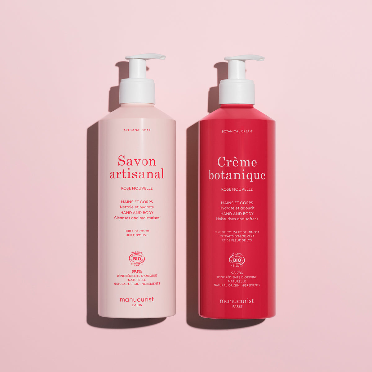 The Rose Botanical Cream Artisan Soap Duo - Cosmos Organic by Manucurist features two pink pump bottles for hand and body care, delicately rose-scented, displayed on a light pink background.