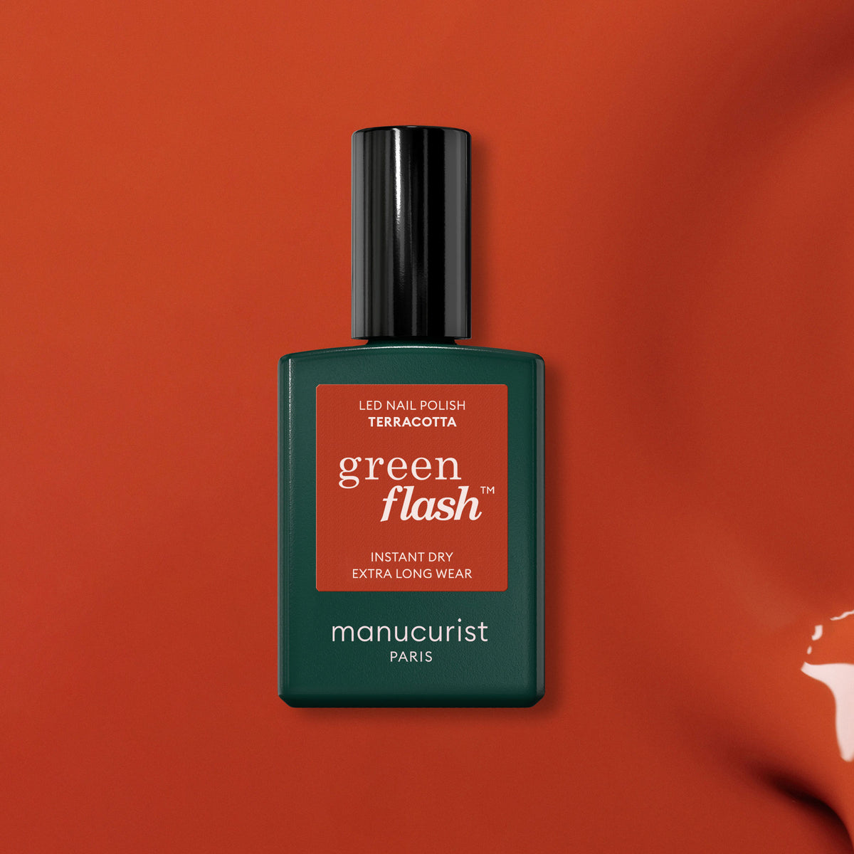 Un flacon de vernis gel Terracotta de Manucurist est présenté sur un fond inspiré de la terre rouge. Le flacon rectangulaire présente un corps vert foncé et un élégant bouchon noir, mettant en valeur la riche teinte Terracotta.