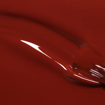 Gros plan de Bohème par Manucurist — une surface rouge brillante et lisse aux sous-tons bruns et aux reflets courbes, évoquant un vernis rouge pour un rendu abstrait et fluide.
