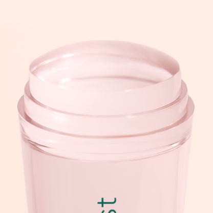 A close-up of the Mani stamper by Manucurist US, a light pink, transparent stick with a rounded, glossy surface, shown against a pale background—evoking the look of flawless French tips.