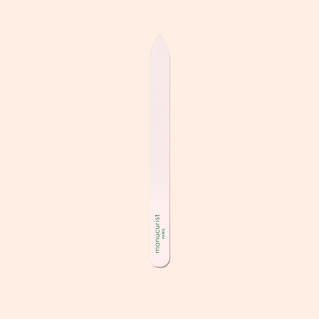 The Manucurist-us Glass Nail File features a pointed tip and "manucurist" in green near the base, shown vertically on a pale beige background.