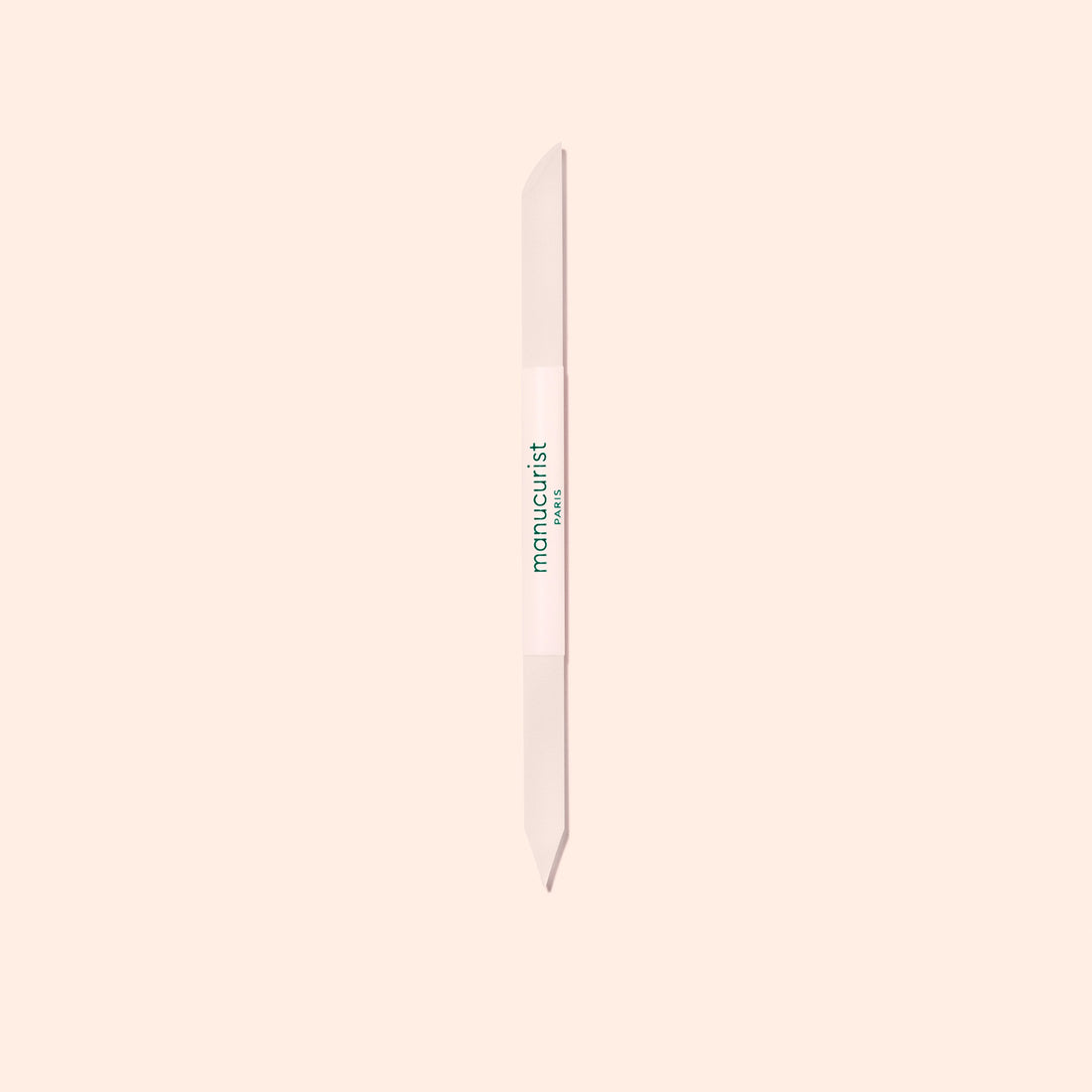 The Manucurist Glass Cuticle Pusher features a pointed tip and beveled edge for precise nail contouring, with "manucurist" in green on a white center section, displayed on a light beige background.