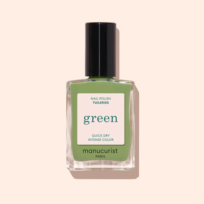 Manucurist Tuileries est un vernis à ongles vert olive clair, avec un bouchon noir et une étiquette blanche minimaliste, présenté sur un fond beige clair.