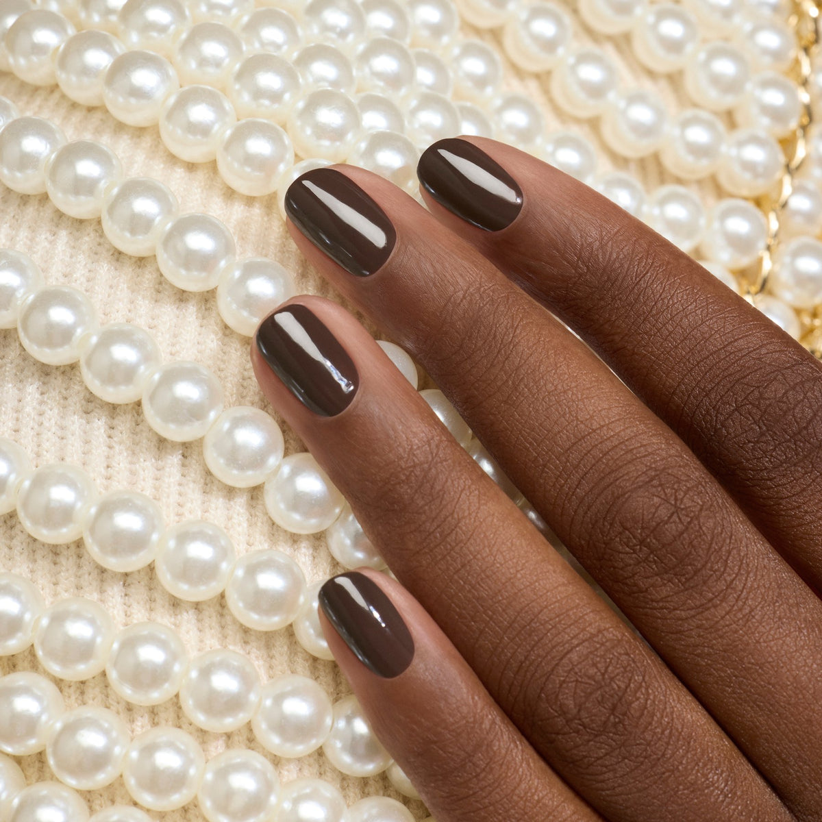 A hand with short nails painted in Manucurist&
