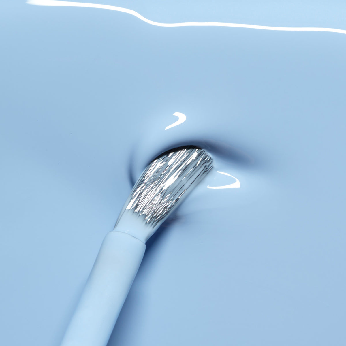A close-up of a brush dipped in Manucurist&