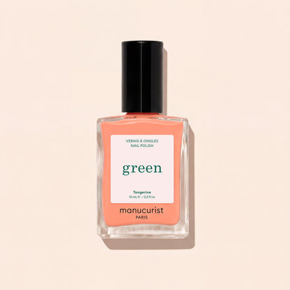 Le vernis à ongles Tangerine de Manucurist présente une teinte orange clair, avec un bouchon noir et une étiquette blanche ornée de texte vert et noir, sur un fond beige clair. Cette couleur vibrante apporte une touche vive à votre look.