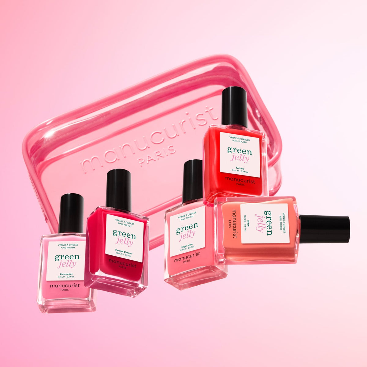 Cinq flacons de vernis à ongles Manucurist dans des teintes roses et corail sont disposés devant un Mini Jelly Bag Manucurist translucide, idéal pour ranger vos vernis, le tout sur un fond dégradé rose poudré.