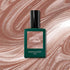 Un flacon de vernis Manucurist Sandstone posé sur un fond marbré et scintillant aux nuances café au lait et beige.