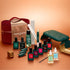 The Manucurist Green Flash™ Super Ultimate Kit Gift Set comes with Green Flash gel polish, nourishing oils, a nail file, a green LED lamp, remover, a velvet case, and essential manicure tools—all beautifully arranged on a warm brown background.