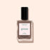 A bottle of Manucurist nail polish in the shade Freckles, a wood-toned brown from their Green™ range, features a black cap and minimalist packaging, displayed on a light beige background.