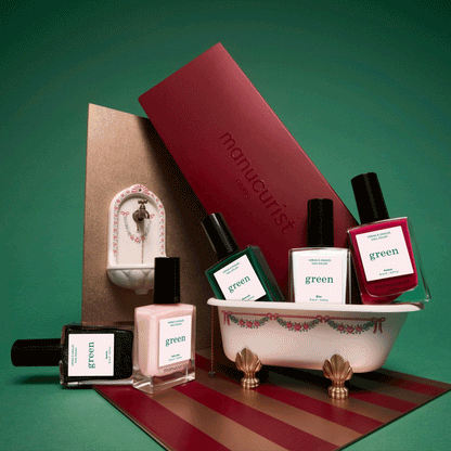 Cinq flacons du lot de 5 personnalisable Manucurist, dont un vernis vert éclatant, sont disposés avec soin autour d’une petite baignoire décorative. À l’arrière-plan, une boîte Manucurist rouge et un lavabo miniature complètent la scène, le tout sur un fond vert vif. Cette mise en scène ludique évoque le plaisir de composer son propre assortiment de vernis arc-en-ciel avec Manucurist.