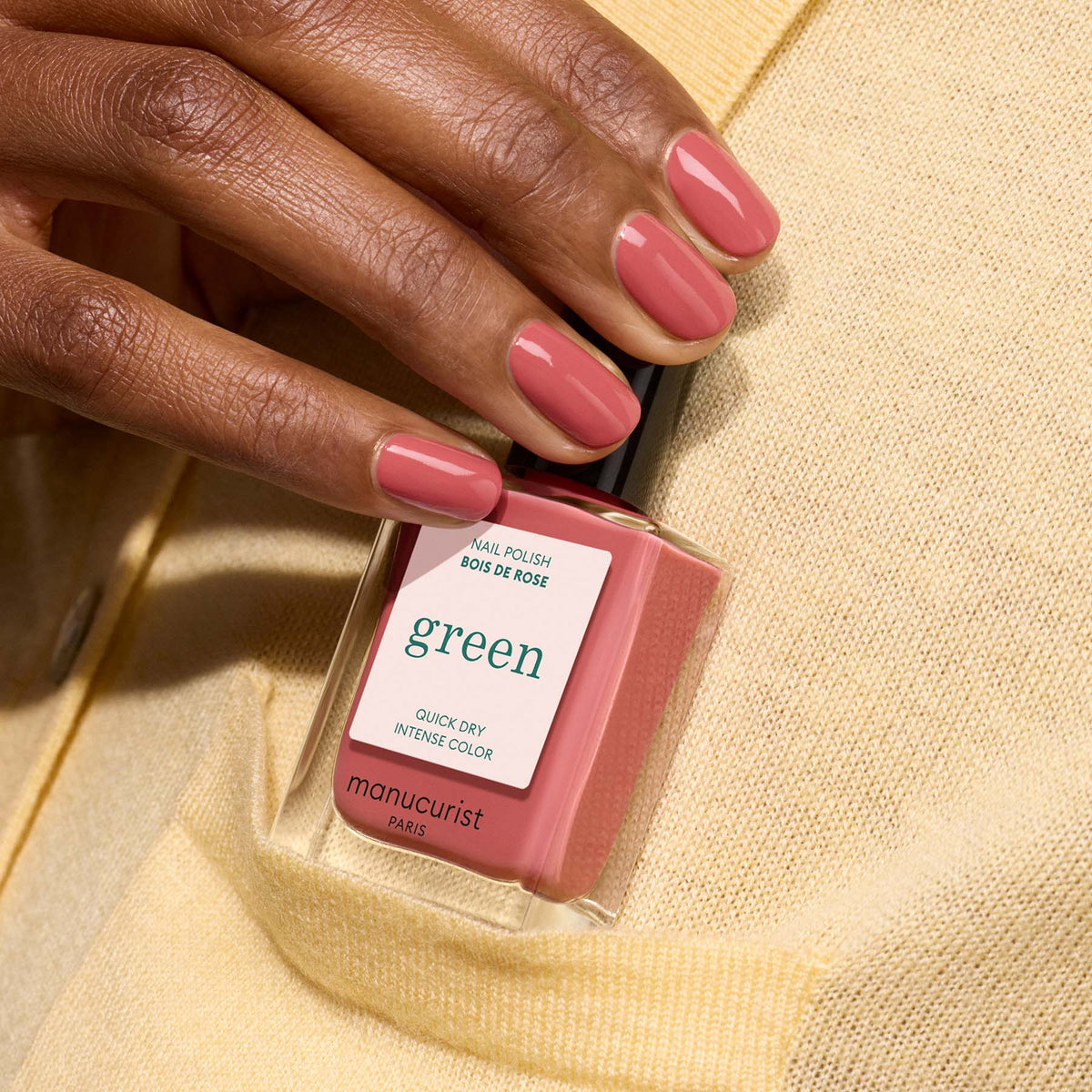 A hand with short, oval nails painted in Manucurist&