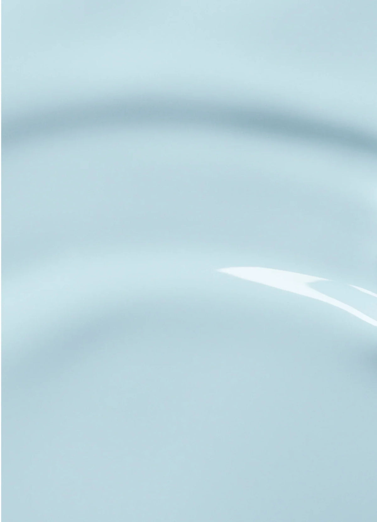 Close-up of a smooth, light blue surface with subtle curved ridges and a glossy reflection, creating an abstract, minimalist appearance.