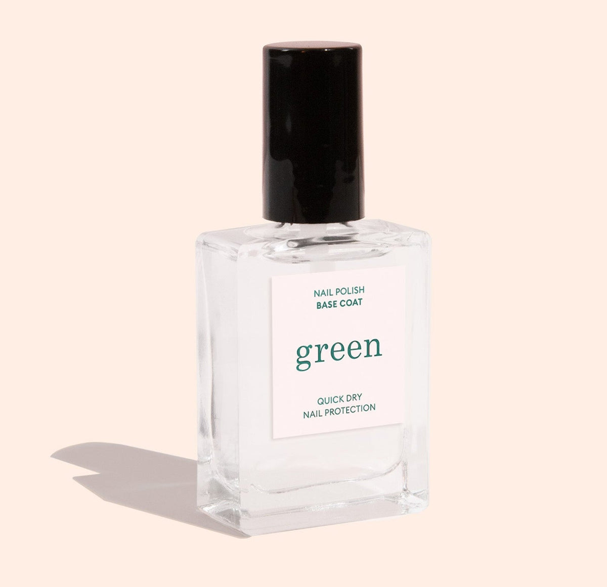 A clear glass bottle of nail polish base coat with a black cap. The label reads green and Quick Dry Nail Protection. The bottle casts a soft shadow on a light beige background.