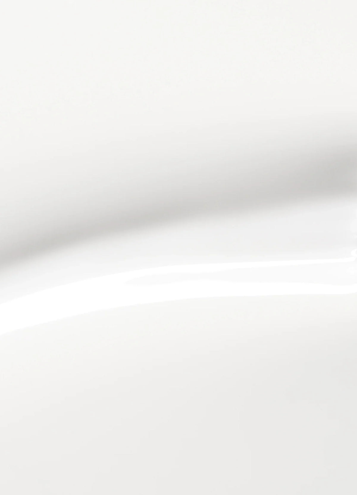 A close-up of a smooth, white, glossy surface with soft shadows and gentle curves, creating an abstract and minimalist appearance.