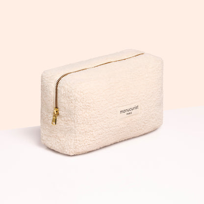 A cream-colored, textured zippered pouch with "Manucurist PARIS" in gold, ideal for carrying your Customizable 5-pack nail polish set by Manucurist, shown against a light neutral background.