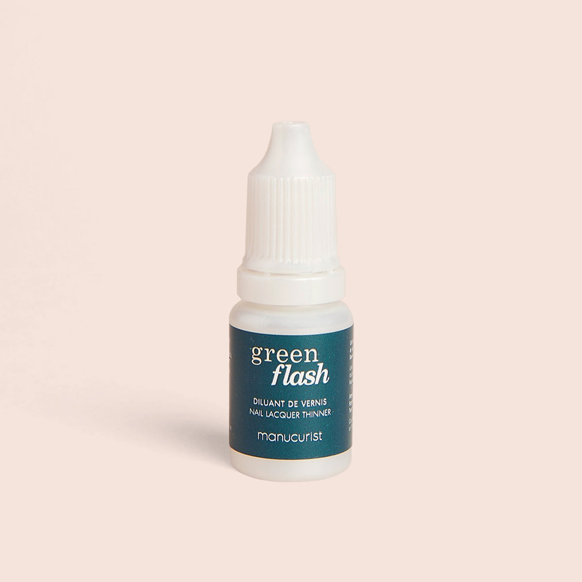 Un petit flacon blanc avec une étiquette vert canard Green Flash™ Polish Thinner de Manucurist-us se tient debout sur un fond beige clair — idéal pour rafraîchir votre vernis gel ou votre Base Coat.