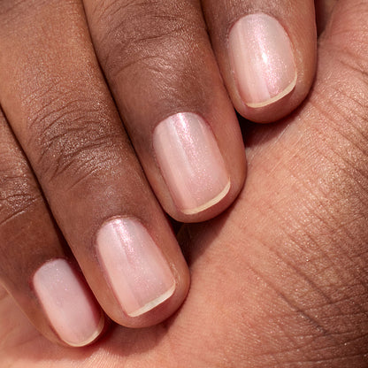 A close-up of a hand with medium brown skin, showcasing neatly manicured nails painted in Manucurist&