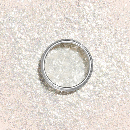 Les Paillettes biodégradables Pearlescent de Manucurist, des paillettes blanches fines dans un pot rond ouvert, posées au milieu de paillettes scintillantes pour créer un effet scintillant — parfaites pour illuminer votre prochaine manucure.