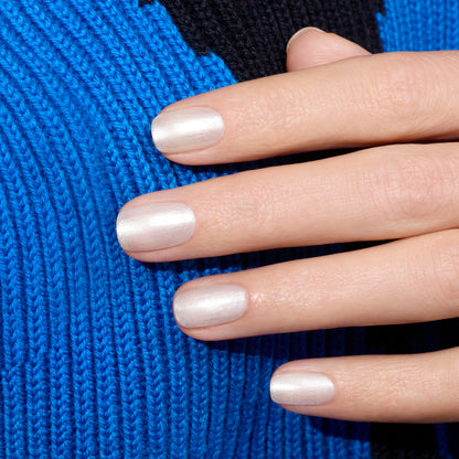 A hand with neatly manicured nails painted in Manucurist&