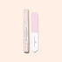 The Glossy Booster Duo by Manucurist—featuring a gentle nail exfoliator and a pink and white nail file—stands upright on a light beige background, perfect for achieving glossy nails.