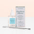 A glass bottle of Manucurist Cuticle Softener  Pusher Duo with a dropper, its box, and a metal pusher on a white surface against a light pink background—ideal for gently softening and removing dead skin around the nail plate.