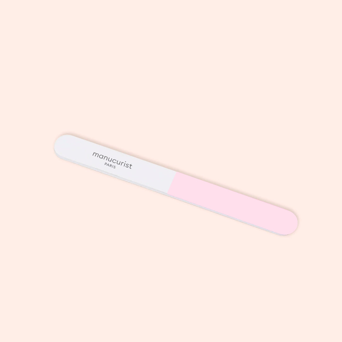 The Manucurist 3-Face Nail Buffer, featuring pink and white sections with "Manucurist" printed on the white side, is shown against a light beige background.