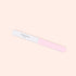 The Manucurist 3-Face Nail Buffer, featuring pink and white sections with "Manucurist" printed on the white side, is shown against a light beige background.