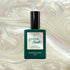 A green bottle of Manucurist Fairy Green Flash LED nail polish with a black cap sits against a shimmery pearl backdrop—ideal for sparkle nails or pairing with pearly white gel polish.