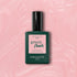 A bottle of Manucurist Satin nail polish with a pink label rests on a pale pink, shimmery background. The label reads: Satin, Green Flash, Instant Dry, Extra Long Wear.