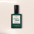 A bottle of Manucurist Crème gel polish in a dark green rectangular bottle with a black cap, standing upright on a light beige background with white light reflections.