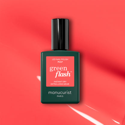 A bottle of Manucurist Pulp gel polish is displayed on a coral pink background with light reflections. The label reads "Pulp, Instant Dry, Extra Long Wear.