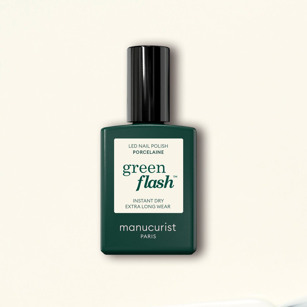 A dark green bottle of Manucurist Porcelaine Green Flash LED gel polish with a black cap stands on a light beige background.