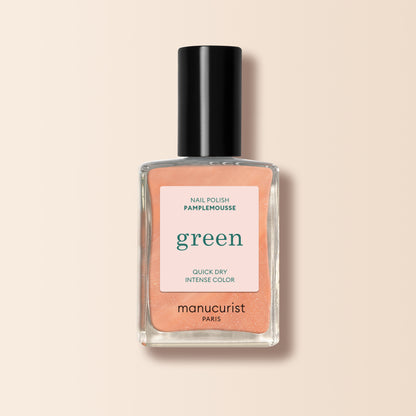 Un flacon de vernis à ongles orange Pamplemousse de Manucurist, dans une teinte orange pêche, avec un bouchon noir et une étiquette mettant en avant sa formule à séchage rapide et à la couleur intense.