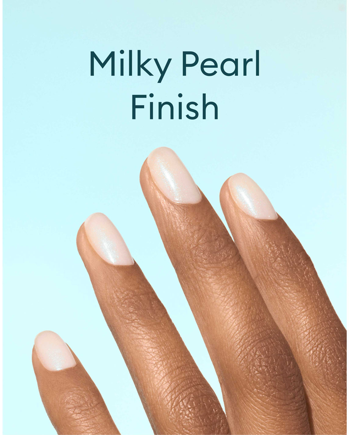 A hand with medium brown skin tone displays nails painted with a milky pearl finish polish against a light blue background. Text above reads, Milky Pearl Finish..